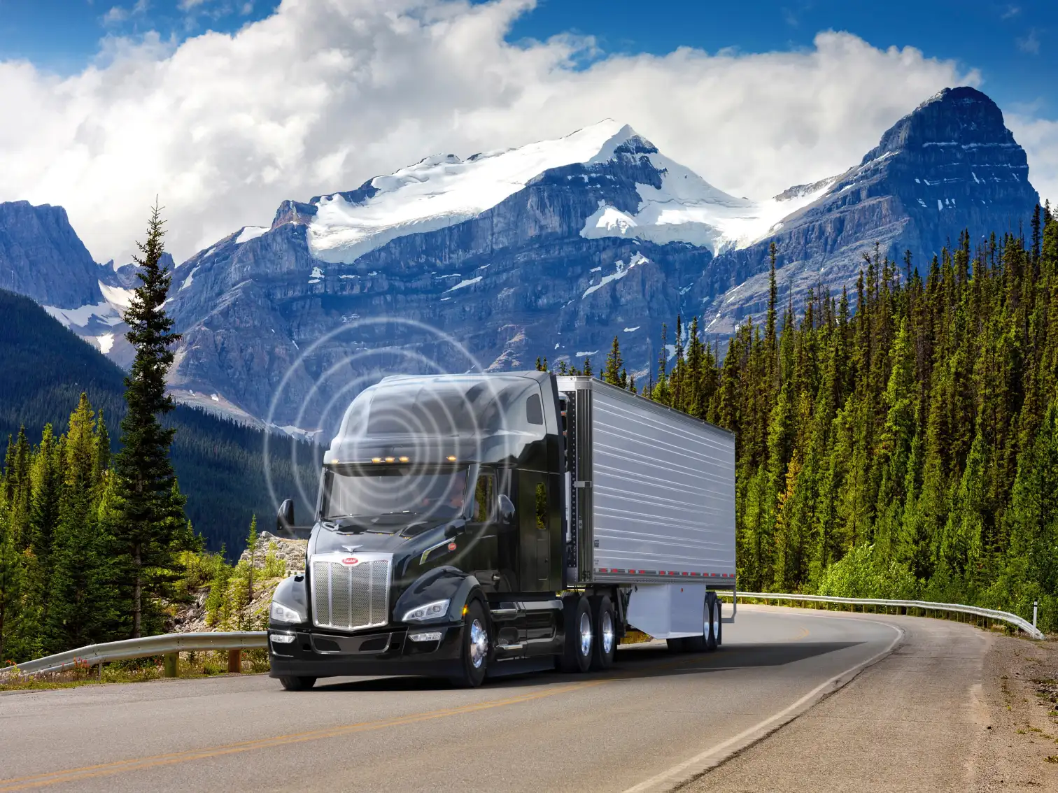 Bluetooth signal emitting from a Peterbilt truck that is driving on a treelined highway